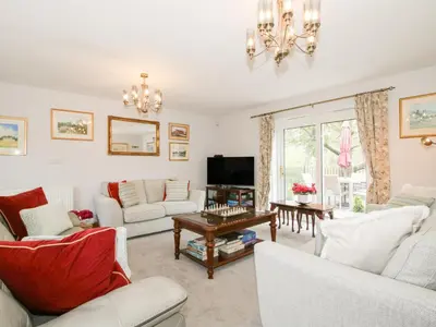 a living room with white furniture and a chandelier at Riverdale in Shrewsbury
