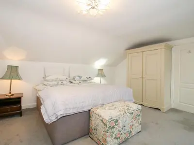 a bedroom with a bed and a cabinet and a ottoman at Riverdale in Shrewsbury