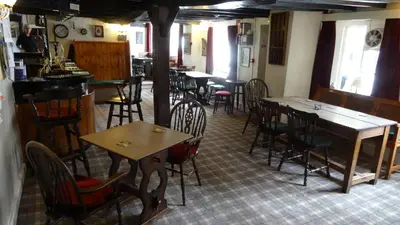 a restaurant with tables and chairs in a room at The Harp Inn in Glasbury