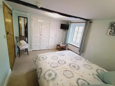 a bedroom with a bed and a window at The Harp Inn in Glasbury
