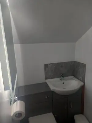 a bathroom with a sink and a toilet at The Harp Inn in Glasbury