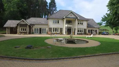 a large house with a fountain in the middle of a yard at Plas Y Dderwen Bed and Breakfast in Aberystwyth