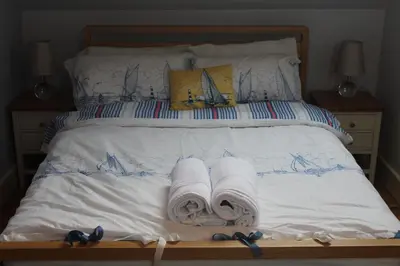 a bed with two rolls of towels on it at Capel- Y-Bryniau in Pennal