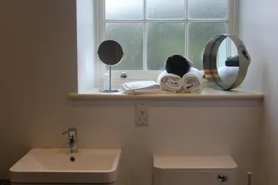 a bathroom with a window and a sink and a mirror at Capel- Y-Bryniau in Pennal