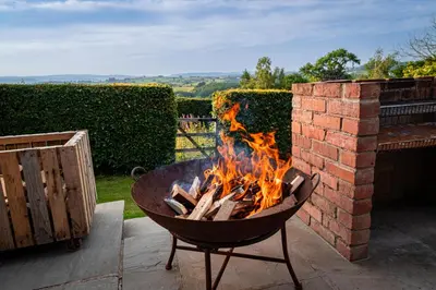 a fire pit sitting next to a brick wall at Wye Cottage in Builth Wells