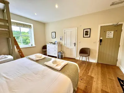 a bedroom with a bed and a desk and a chair at RIVERBANC in Llangollen