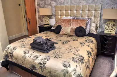 a bedroom with a bed with a blue and white comforter at Peniarth arms in Llanegryn