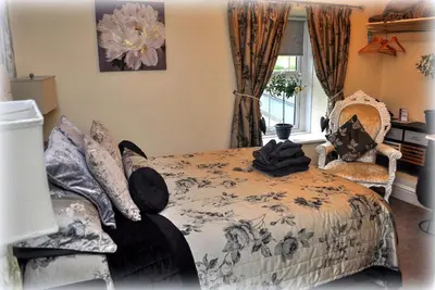 a bedroom with a bed and two chairs and a window at Peniarth arms in Llanegryn