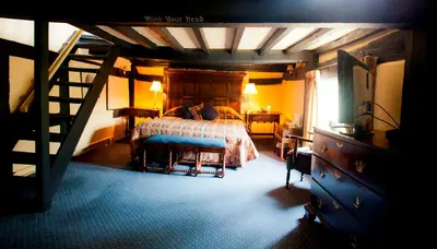 a bedroom with a bed and a staircase in it at The Old Black Lion in Hay-on-Wye