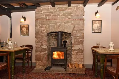 a fireplace in the dining room of a restaurant at The Old Black Lion in Hay-on-Wye