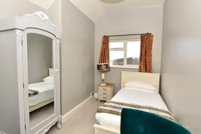 a small bedroom with a bed and a mirror at The Old Black Lion in Hay-on-Wye