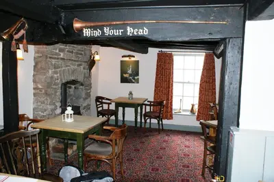 a dining room with two tables and a fireplace at The Old Black Lion in Hay-on-Wye