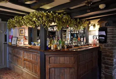 a bar with a lot of bottles of alcohol at The Old Black Lion in Hay-on-Wye