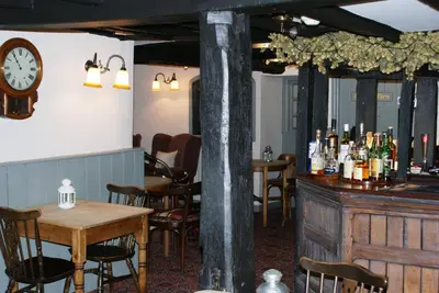 a restaurant with a table and a clock on the wall at The Old Black Lion in Hay-on-Wye