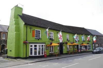 a green building with flags on it on a street at Elan Hotel in Rhayader