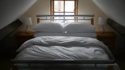 a bed with white sheets and pillows in a room at The Keep in Ludlow