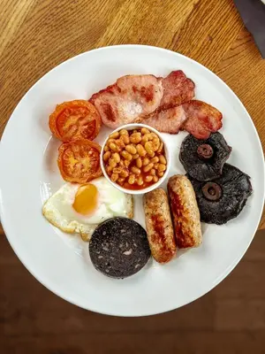 a plate of breakfast food with eggs bacon and beans at The Corbet Arms in Shrewsbury