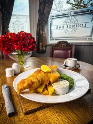 a plate of food with fish and chips on a table at The Corbet Arms in Shrewsbury