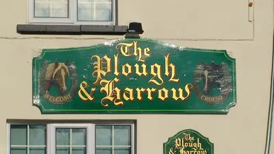 a green sign on the side of a building at Plough and Harrow in Brecon