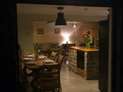 a dining room and living room with a table and a kitchen at Chapel House Cottage in Builth Wells