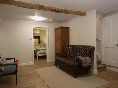 a living room with a couch and a bedroom at Chapel House Cottage in Builth Wells