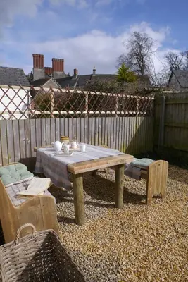 a wooden table and bench in a backyard with a fence at Number 22, Castle Street in Hay-on-Wye