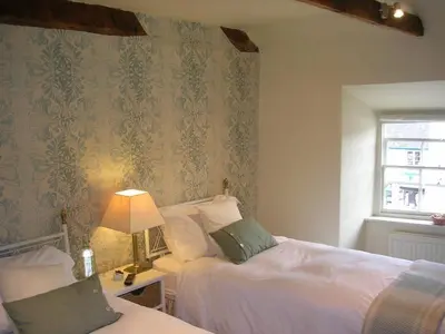 a bedroom with two beds and a lamp on a table at The Drovers Bed and Breakfast in Llandovery