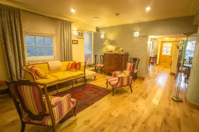 a living room with a yellow couch and chairs at The Drovers Bed and Breakfast in Llandovery