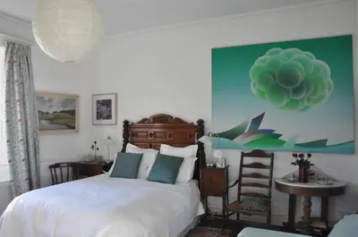 a bedroom with a bed and a green wall at Mid Wales Arts B&B in Caersws