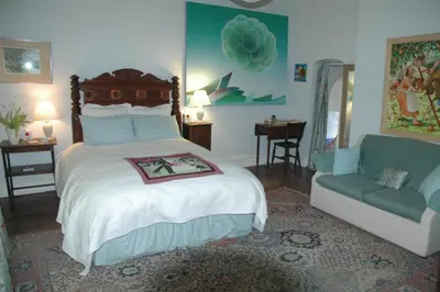 a bedroom with a large bed and a couch at Mid Wales Arts B&B in Caersws