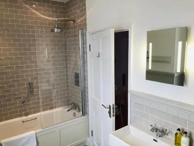 a bathroom with a tub and a sink and a mirror at Harbourmaster Hotel in Aberaeron