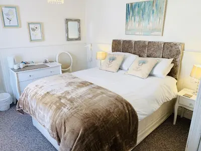 a bedroom with a large bed and a nightstand with a bed sidx sidx sidx at Cambrian House in Llangollen