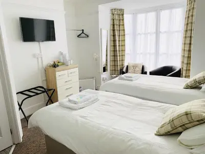 a hotel room with two beds and a television at Cambrian House in Llangollen