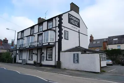 a white building with a sign on the side of it at Cambrian House in Llangollen