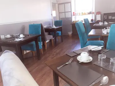 a dining room with wooden tables and blue chairs at Cambrian House in Llangollen