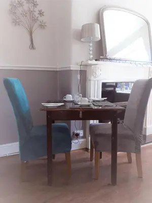 a dining room table with two chairs and a mirror at Cambrian House in Llangollen