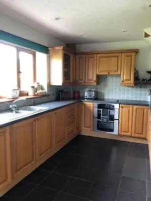 a kitchen with wooden cabinets and a stove at Nant-Y-Glyn in Llandrindod Wells