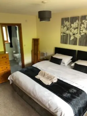 a bedroom with two beds and a bathroom at Nant-Y-Glyn in Llandrindod Wells