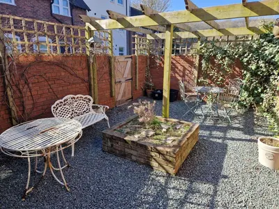 a patio with a table and chairs and a wooden pergola at Ludlow - Linnet House - Well Presented Townhouse With Parking - Perfect Location For Exploring On Foot, Sleeps Up To 8 Guests - Hosted by RENTMYHOUSE in Ludlow