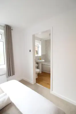 a bedroom with a white bed and a bathroom at The annex at 44 Belvidere Road in Shrewsbury