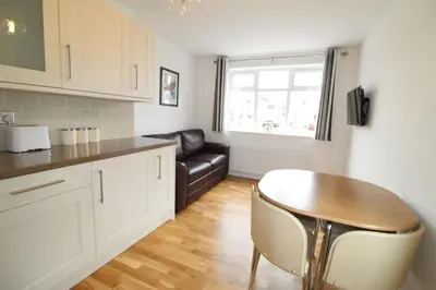a kitchen with a table and a leather couch at The annex at 44 Belvidere Road in Shrewsbury