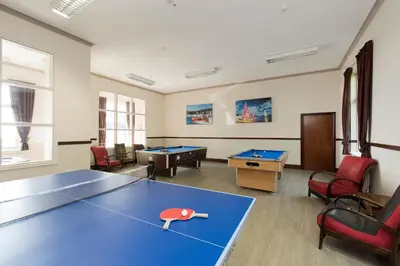 a room with a ping pong table and chairs at Trefeddian Hotel in Aberdyfi
