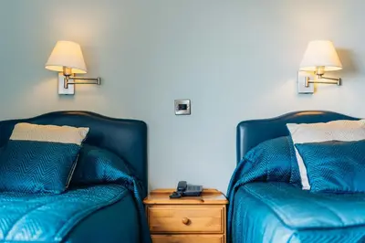 two beds sitting next to each other in a room at Trefeddian Hotel in Aberdyfi