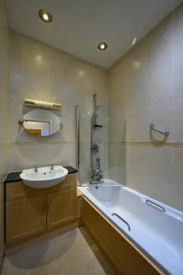 a bathroom with a tub and a sink and a bath tub at Trefeddian Hotel in Aberdyfi