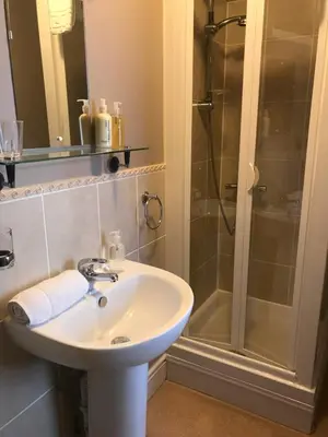 a bathroom with a sink and a shower at Endeavour Guest House in Barmouth