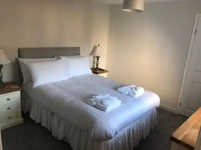 a bedroom with a bed with two towels on it at Pengarreg Fawr in Llanilar