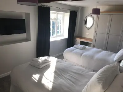 a hotel room with two beds and a television at Pengarreg Fawr in Llanilar