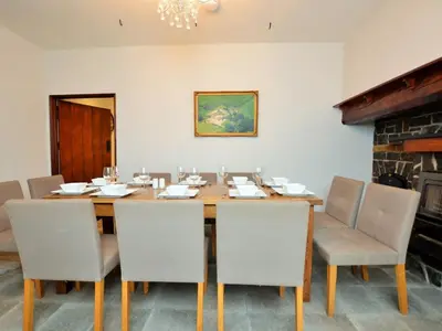 a dining room with a wooden table and chairs at Pengarreg Fawr in Llanilar