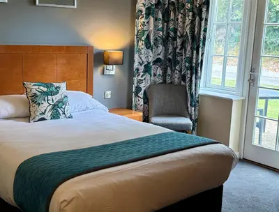 a hotel room with a bed and a chair at Wild Pheasant Hotel & Spa in Llangollen