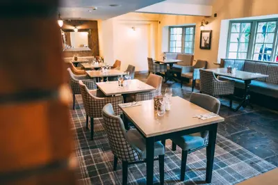 a restaurant with tables and chairs in a room at Wild Pheasant Hotel & Spa in Llangollen